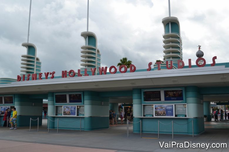 Foto do portal de entrada do Hollywood Studios, pintado de azul com o nome do parque em vermelho 