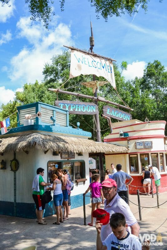 Os parques aquáticos são quase desertos para trocar o e-ticket. Foto do Will Call no Typhoon Lagoon, com uma bandeira pirata dizendo "Welcome" e o nome do parque em placas de madeira abaixo. 