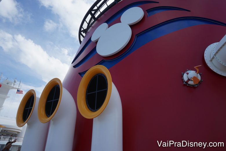 Foto do navio de cruzeiro da Disney, pintado de vermelho com detalhes que remetem à roupa do Mickey 