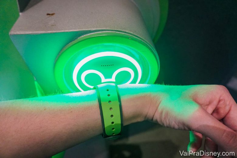 A felicidade de ver essa luz ficar verde e entrar na fila de Fastpass+, sempre beeeem menor que a fila normal. Foto de uma mão com uma MagicBand verde sendo escaneada em uma atração da Disney, no totem de Mickey que fica verde para autorizar a entrada