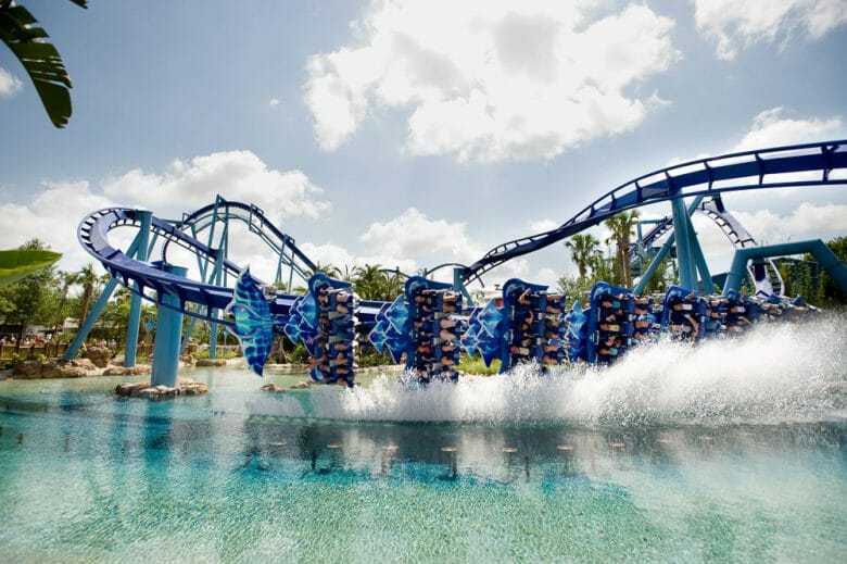 Manta: Passeio em uma raia é uma das atrações mais emocionantes do SeaWorld. Foto da montanha-russa Manta, do SeaWorld, que mostra o carrinho de ponta-cabeça e entrando na água, com alguns trilhos pintados de azul ao fundo. 