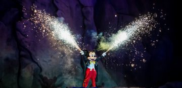Foto do Mickey durante o Fantasmic, segurando tubos que soltam fogos de artifício.