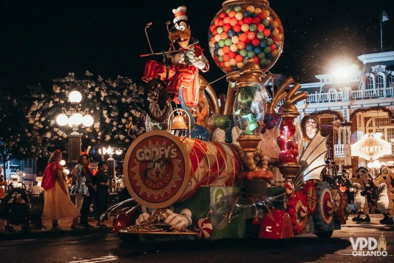 Imagem de um dos carros da parada de Halloween, com o Pateta em cima.  Há um globo gigante com doces atrás dele. 