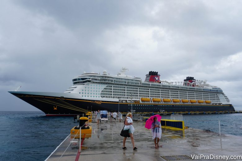 Foto do Disney Fantasy parado em Cozumel, com o céu nublado ao fundo. 