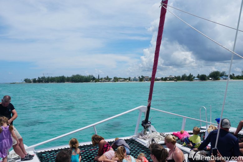 Foto dos visitantes a bordo do barco, com o mar verde-água e o céu limpo ao fundo 