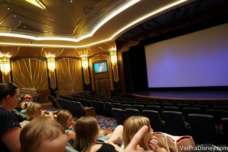 Foto dos visitantes esperando para sair para o passeio no Buena Vista Theatre, no navio Disney Fantasy 