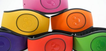 Foto de uma pilha de MagicBands da Disney nas cores rosa, amarela, laranja, vermelha e verde