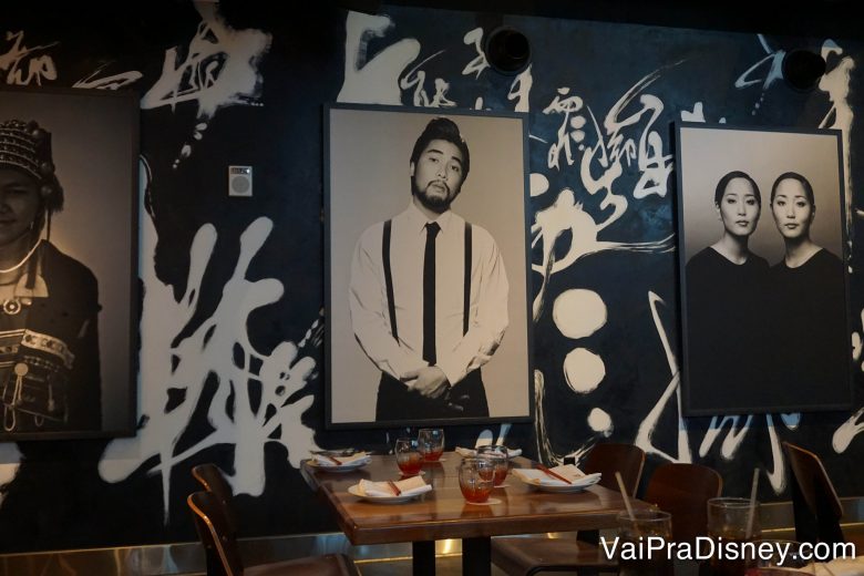 Alguns quadros presentes na decoração, com um papel de parede escuro com ideogramas japoneses atrás 