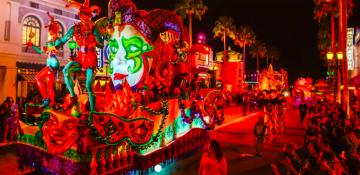 Foto da comemoração de Mardi Gras na Universal, com a parada passando pelo parque e a iluminação vermelha.