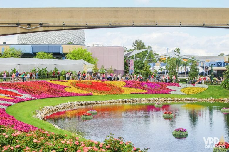 Imagem do Flower & Garden Festival do Epcot em maio. É possível ver o lago com as flores ao redor, formando Mickeys e outros desenhos. 