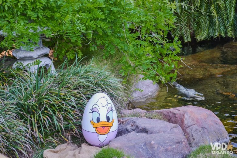 A Páscoa pode deixar os parques mais cheios em abril. Foto de um ovo de páscoa pintado com a Margarida, sobre uma pedra à beira do lago. 