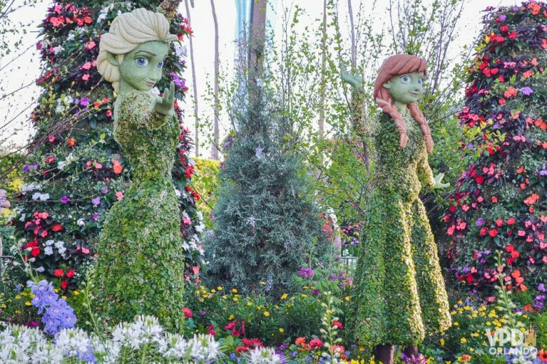 Óbvio que elas não ficariam de fora do Flower & Garden Festival que acontece também em Abril! Foto das topiárias das personagens Elsa e Anna, de Frozen, com árvores floridas ao redor.  