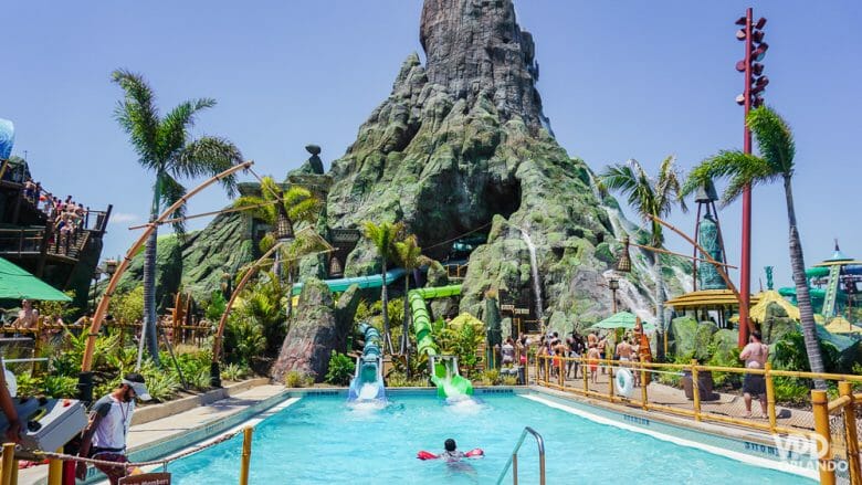 Em alguns dias quentes de Abril eu começo a considerar a me aventurar nos parques aquáticos de Orlando. Foto de uma piscina cheia de visitantes no Volcano Bay, com o vulcão que é símbolo do parque ao fundo. 