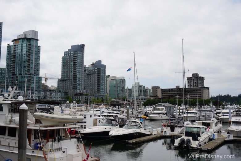 Foto de diversos barcos no porto de Vancouver, com os prédios da cidade ao fundo 