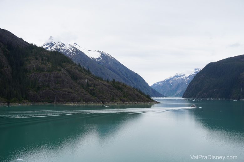 Imagem da paisagem do Alasca, com montanhas com neve no topo e o mar.