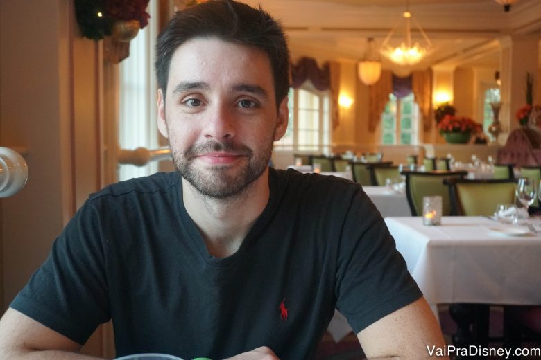 Felipe sentado à mesa e sorrindo 