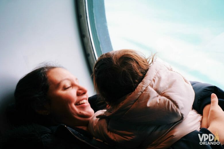 Imagem da Re com sua filha em uma janela do navio Disney Wonder, durante o dia para ver geleiras.