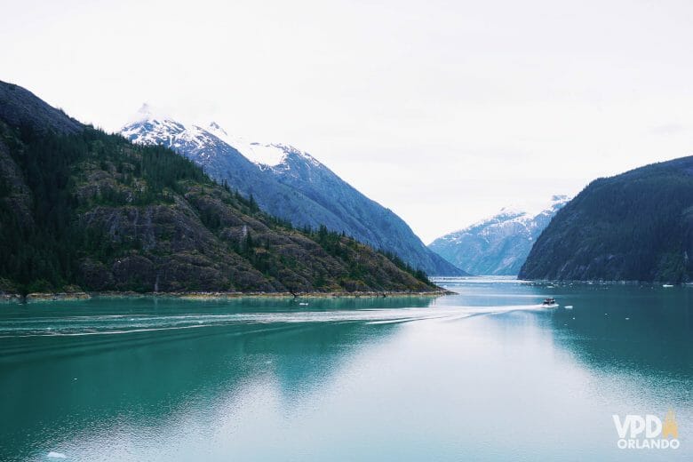 Imagem da paisagem do Alasca, com montanhas com neve no topo e o mar.