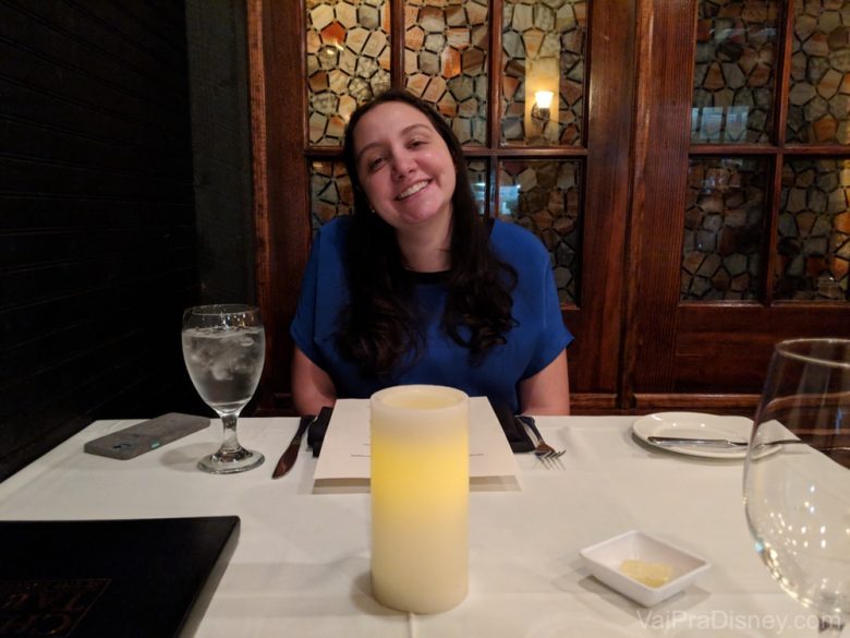 Foto da Renata sorrindo, sentada à mesa do Chef's Table at the Edgewater