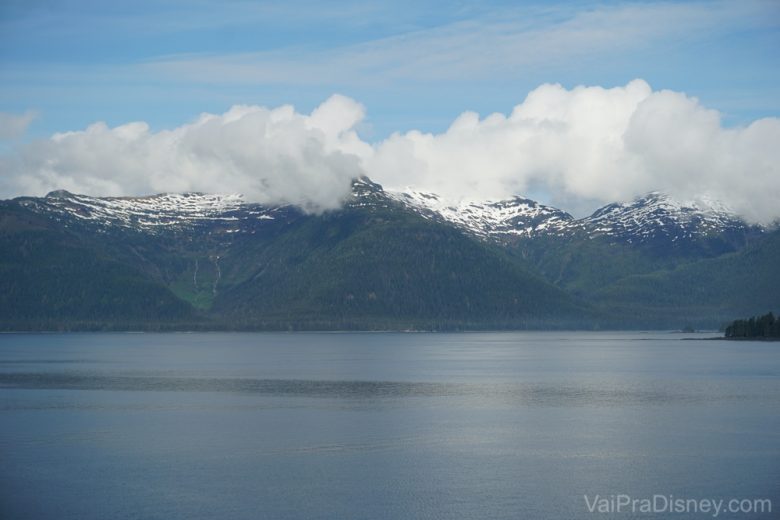 Foto da vista durante o cruzeiro, com as montanhas do Alaska, o mar e as nuvens 