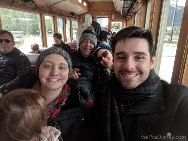 Foto da Renata e do Felipe com a Julia no colo e os pais da Renata atrás, no trem do passeio 