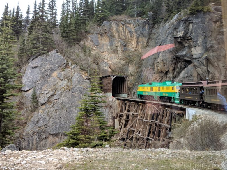 Foto do trem passando pela estrada de ferro no meio da montanha 