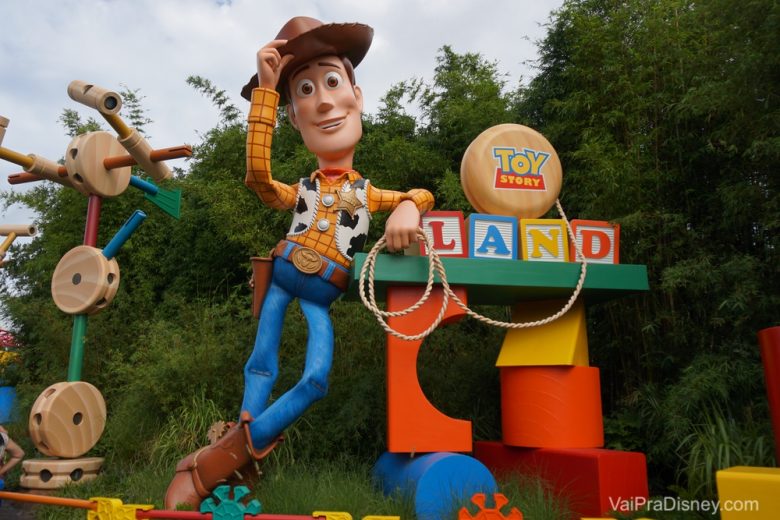 Foto do boneco gigante do Woody na Toy Story Land do Hollywood Studios, com os brinquedos que compõem o cenário ao seu lado. 