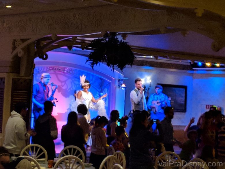 Foto do jantar temático com música ao vivo e a princesa Tiana no palco 