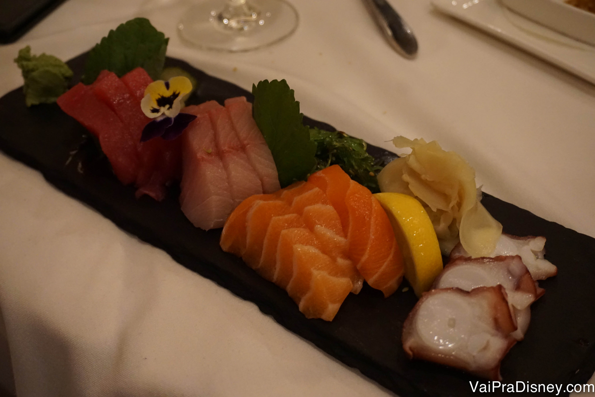 Foto de um prato de comida japonesa, com sushi, polvo e diferentes tipos de sashimi 