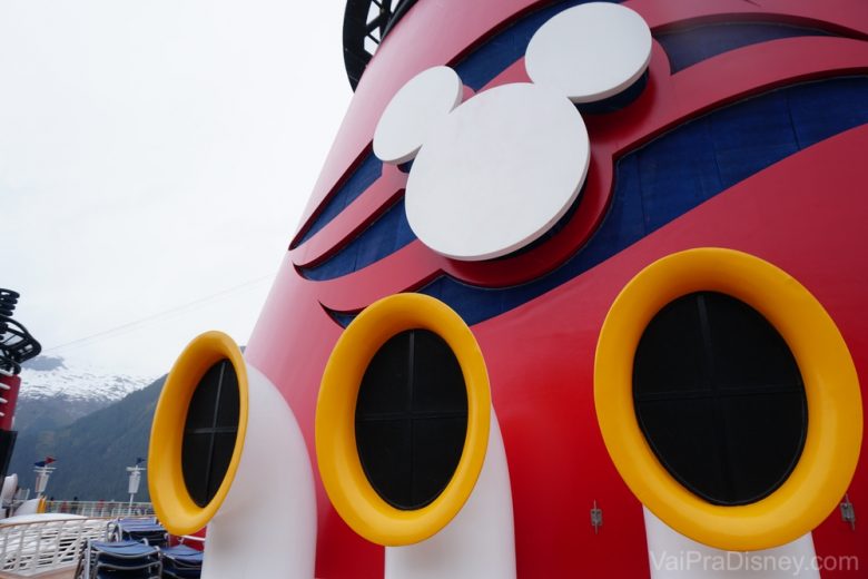 Foto de um detalhe do navio da Disney Cruise Line, o Disney Fantasy, com o Mickey em branco e o fundo pintado de azul e vermelho.