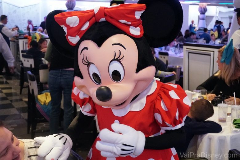 Foto da Minnie interagindo com visitantes em uma refeição com personagens 