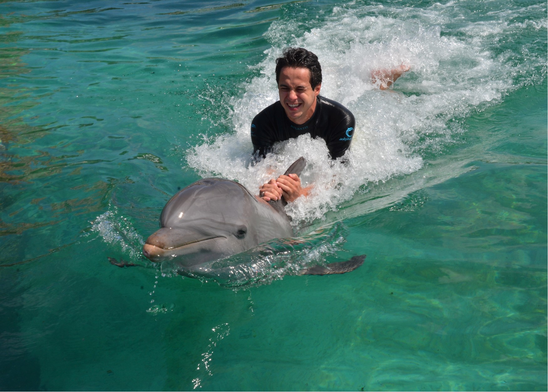 Foto do Henrique com o golfinho durante o cruzeiro da Disney, no Atlantis das Bahamas 