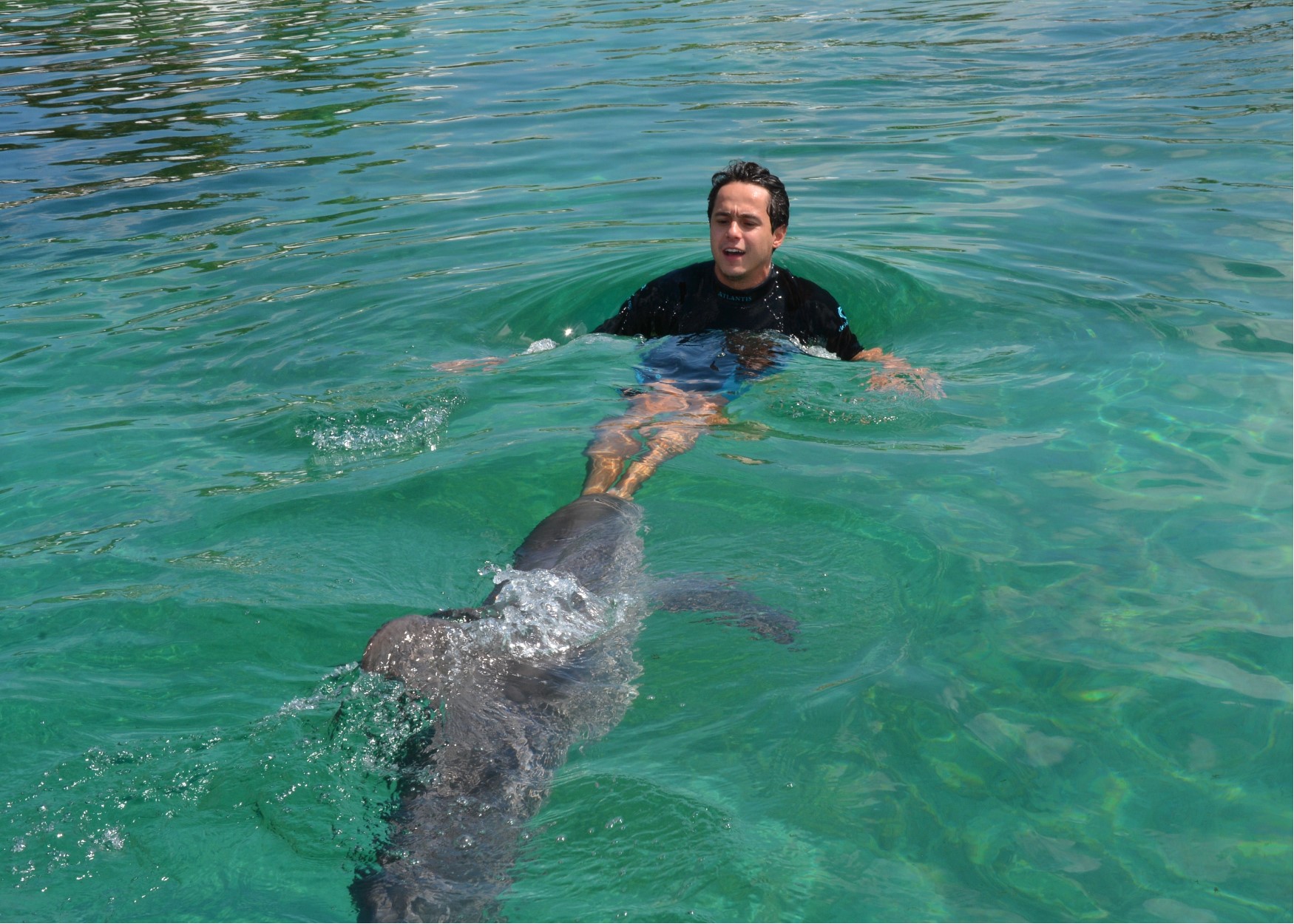 Foto do Henrique com o golfinho durante o cruzeiro da Disney, no Atlantis das Bahamas 