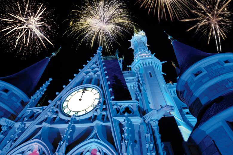 Os fogos de ano novo do Magic Kingdom. Um espetáculo imperdível. Foto: Divulgação Disney Foto do castelo da Cinderela iluminado em azul durante o show de fogos de Ano Novo no Magic Kingdom. É possível ver alguns fogos no céu acima do castelo. 