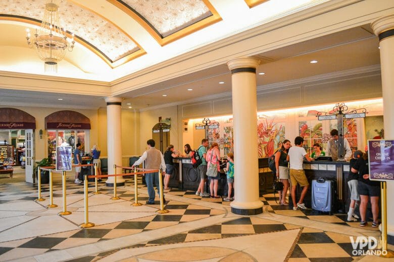 O check-in é um dos únicos momentos onde é necessário interagir em inglês no hotel. Foto da recepção de um hotel, com visitantes fazendo check-in