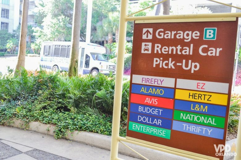 O inglês pode ser necessário na hora de retirar o carro alugado! Foto da placa das locadoras de carro no aeroporto, com as palavras "garage" e "rental car pick-up" e a lista de locadoras abaixo 