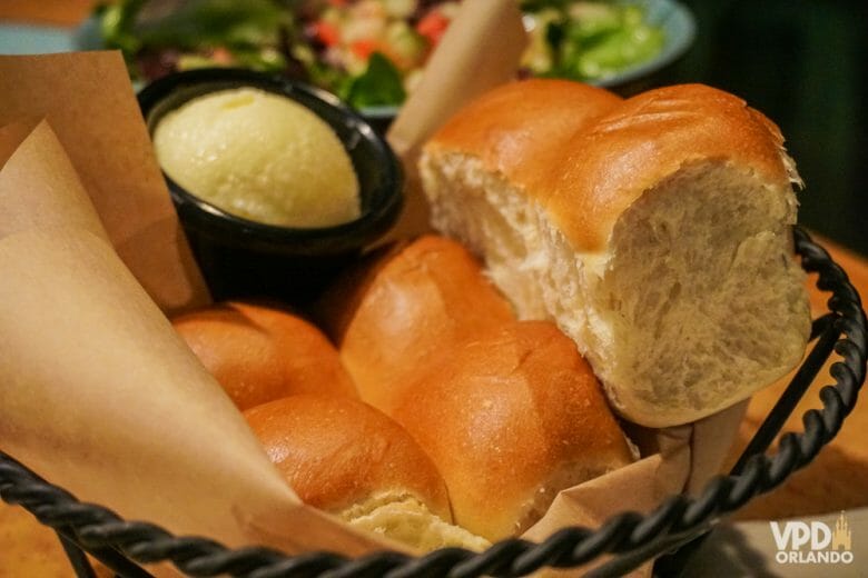 Nos EUA, esse pãozinho com manteiga de entrada é cortesia :). Foto da cesta de pães com a manteiga ao lado em um restaurante 