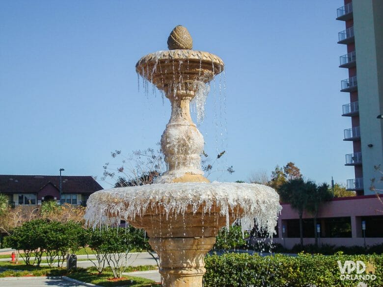 Essa foto foi tirada em uma manhã de janeiro no Blue Heron, hotel pertinho da Disney! Foto de uma fonte com a água congelada e o céu azul ao fundo. 