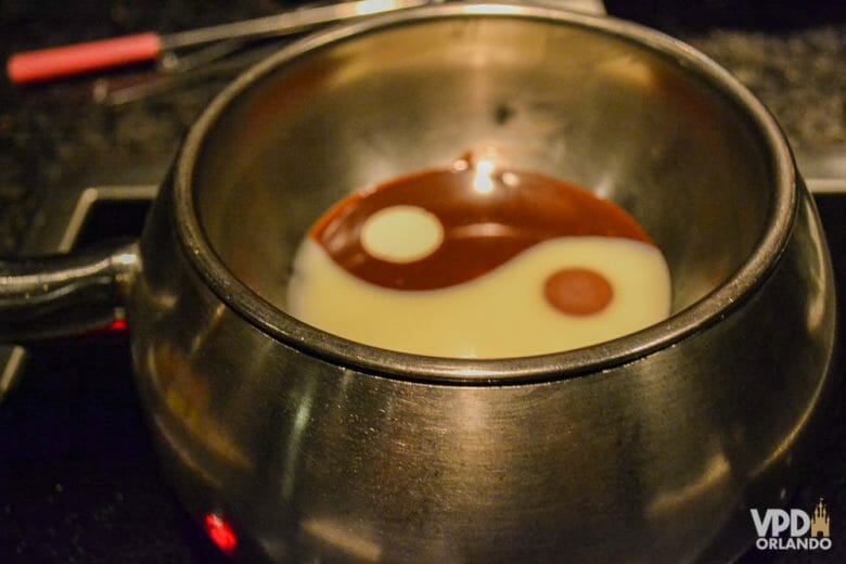 Como eu lido com o frio de janeiro! Foto de uma panelinha de fondue. O chocolate branco e preto forma um ying-yang dentro da panela 