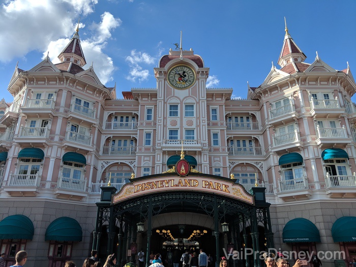 Foto da entrada da Disneyland Paris, com uma construção pintada de rosa no estilo da Main Street com um relógio do Mickey em seu centro. 