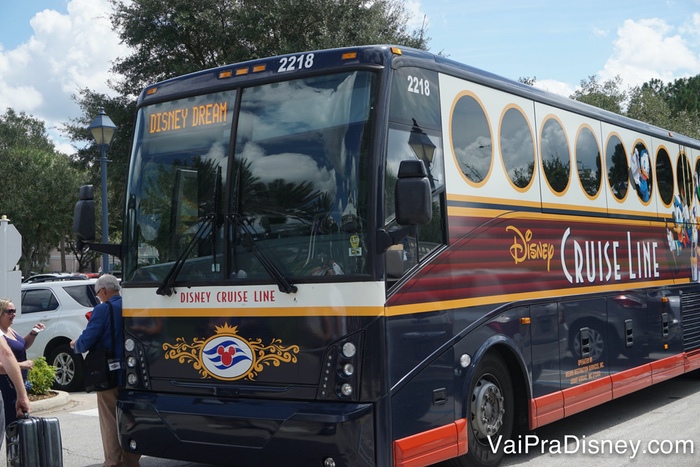 Os ônibus da Disney podem ser uma alternativa cômoda de ir para o porto para quem vai se hospedar na Disney. Foto do ônibus da Disney Cruise Line que pode levar os visitantes ao porto no dia do embarque. Ele é azul marinho com detalhes em branco, amarelo e vermelho. 