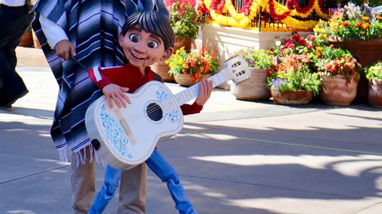 Foto do show de Coco no Epcot, mostrando um fantoche do personagem Miguel com seu violão 