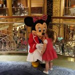Foto da Minnie recebendo um beijo de uma criança durante um dos cruzeiros da Disney