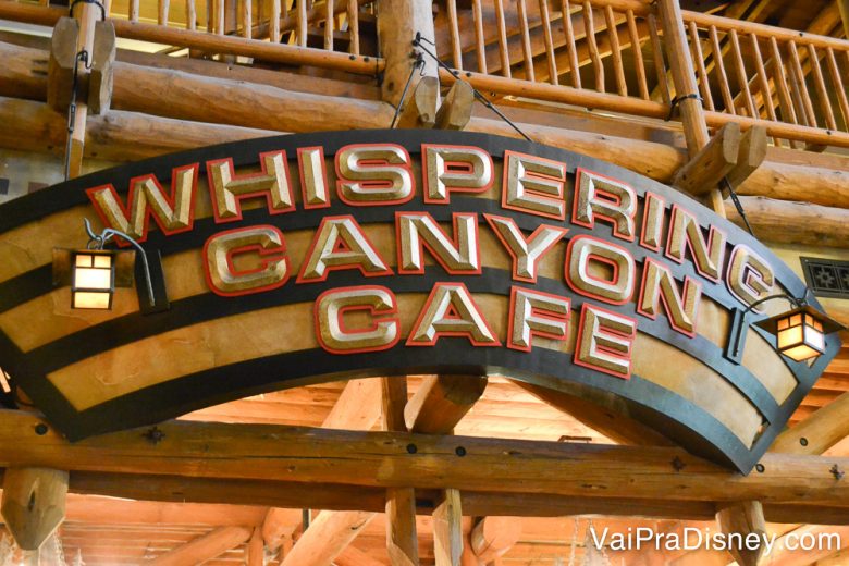 Restaurante delicioso e super divertido! Foto da placa na entrada do restaurante Whispering Canyon Café, toda em madeira com o nome do local em letras grandes. 