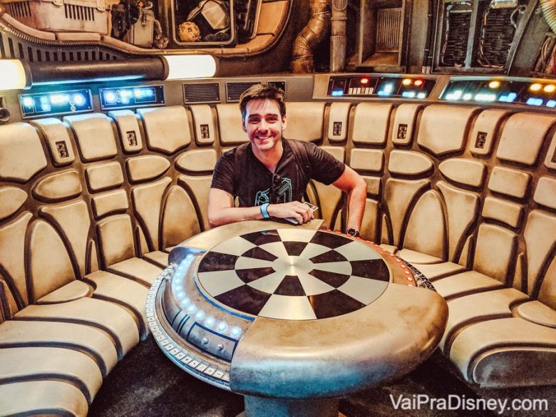 Imagem do Felipe sentado à mesa de xadrez da Millenium Falcon, na Star Wars Galaxy's Edge