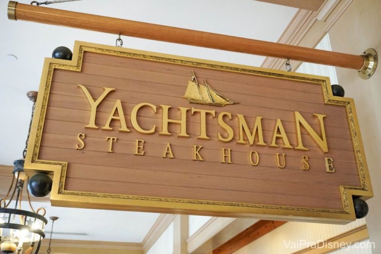 Foto da placa no restaurante Yachtsman Steakhouse, em madeira clara com detalhes dourados 