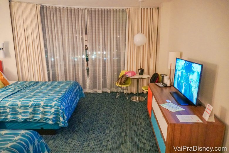 Foto do quarto padrão do Cabana Bay, com 2 camas, móvel com TV e carpete, bastante espaçoso 