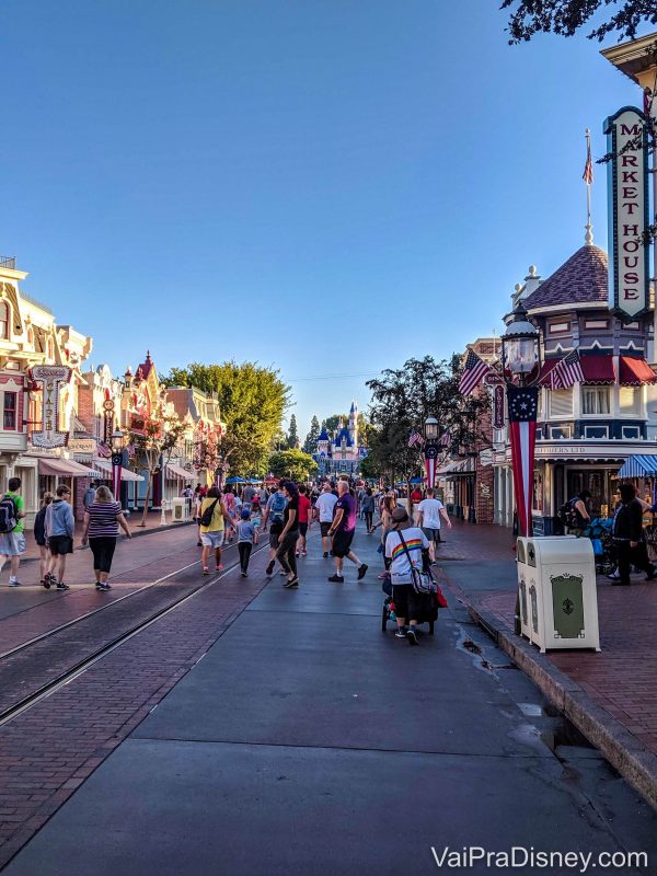 Foto do castelo da Bela Adormecida na Disneyland, ao fundo da Main Street movimentada 