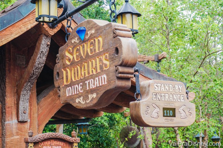 Foto da entrada da Seven Dwarfs Mine Train no Magic Kingdom. As placas de madeira exibem o nome da atração e "stand-by entrance" com o tempo de espera abaixo 