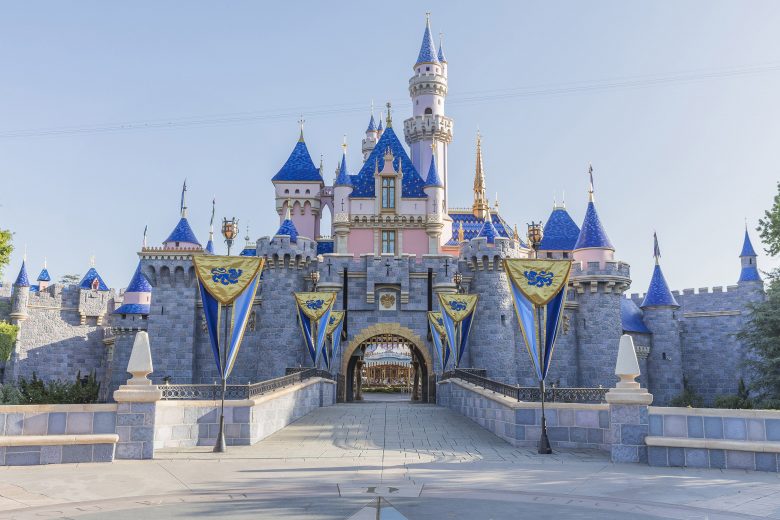 Foto do castelo da Bela Adormecida na Disneyland da Califórnia, com detalhes em rosa, azul e dourado. 